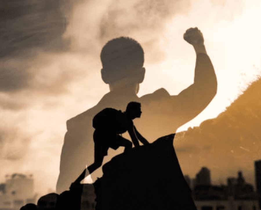 Silhouette of a child climbing, arm raised in triumph